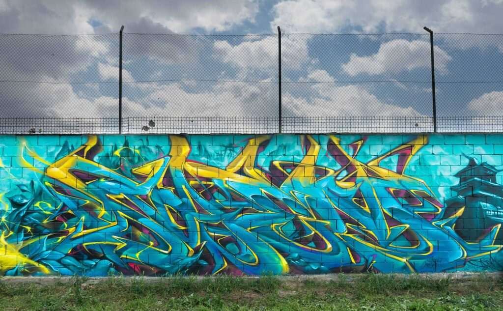 Graffiti de dragón lanzando fuego sobre fondo azul