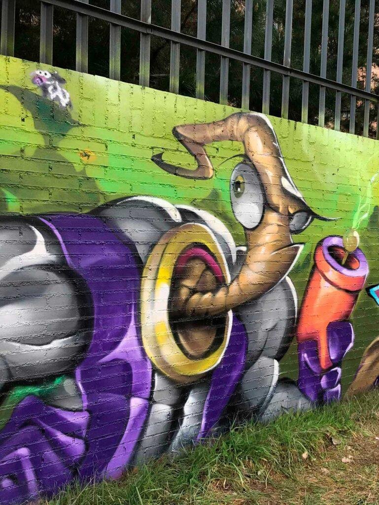 Mural graffiti de Earthworm Jim con raygun sobre fondo verde neón