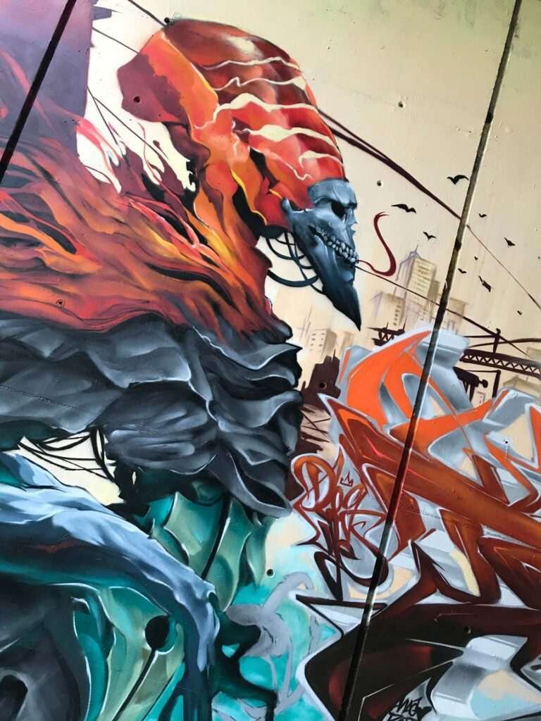 Graffiti de faraón egipcio con calavera y llamas en mural urbano