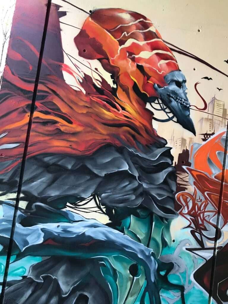 Graffiti de faraón egipcio con calavera y llamas en mural urbano