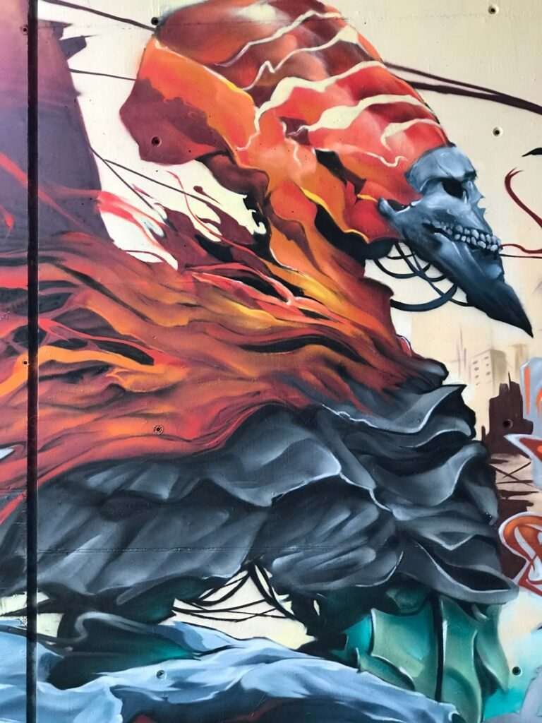 Graffiti de faraón egipcio con calavera y llamas en mural urbano
