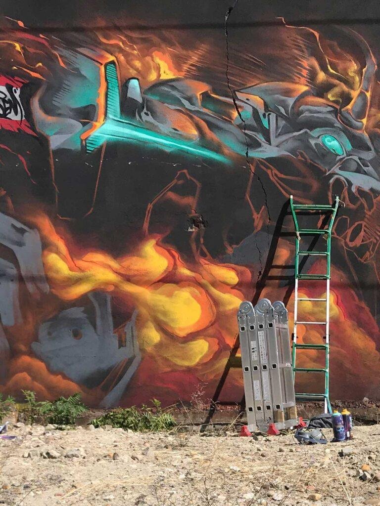 Mural graffiti Evangelion con mecha en llamas y energía