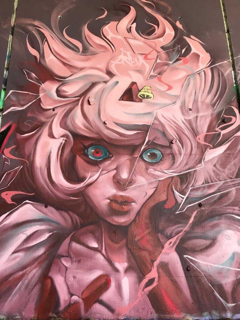 Mural urbano con retrato de hada fantástica entre cristales rotos
