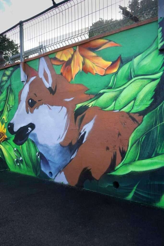 Vista general del mural exterior con animales y vegetación en el hotel de mascotas de Tenerife