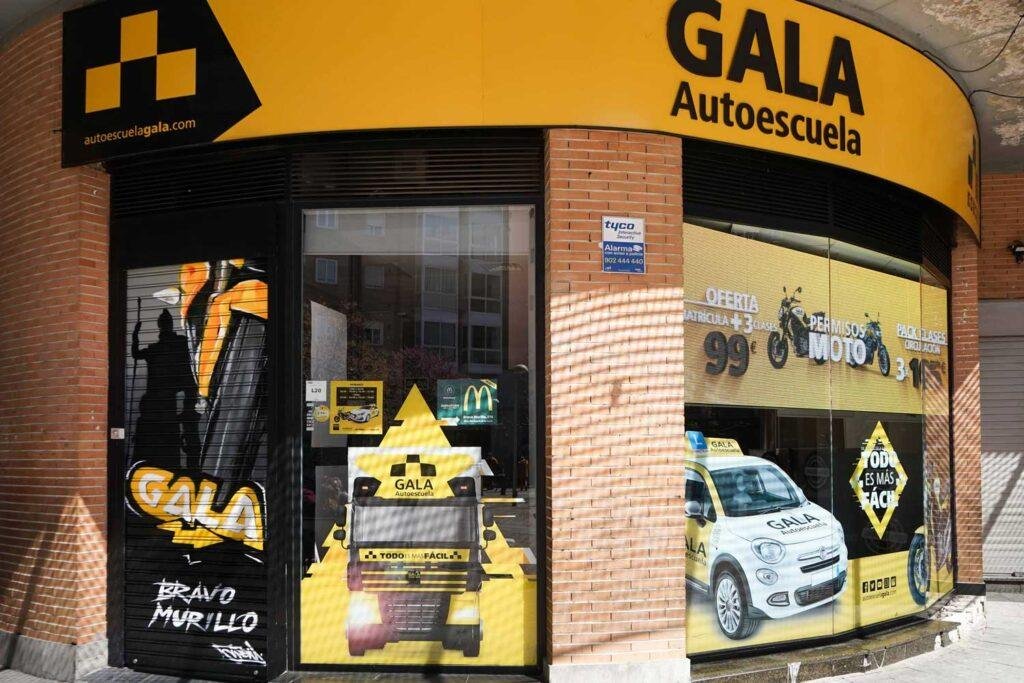 Moto deportiva amarilla y silueta urbana en mural para Gala Bravo Murillo, Madrid