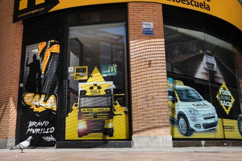 Moto deportiva amarilla y silueta urbana en mural para Gala Bravo Murillo, Madrid