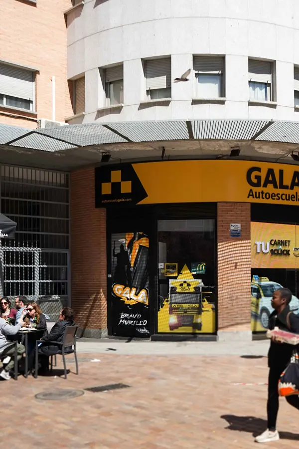 Moto deportiva amarilla y silueta urbana en mural para Gala Bravo Murillo, Madrid