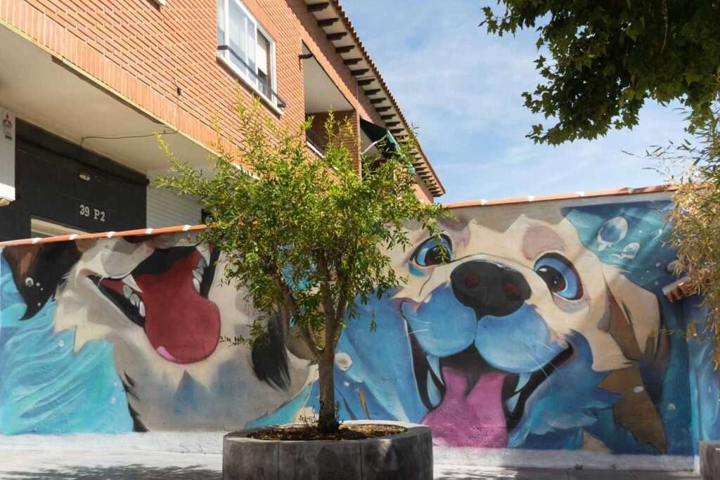 Mural con perros felices en fachada de clínica veterinaria en Toledo