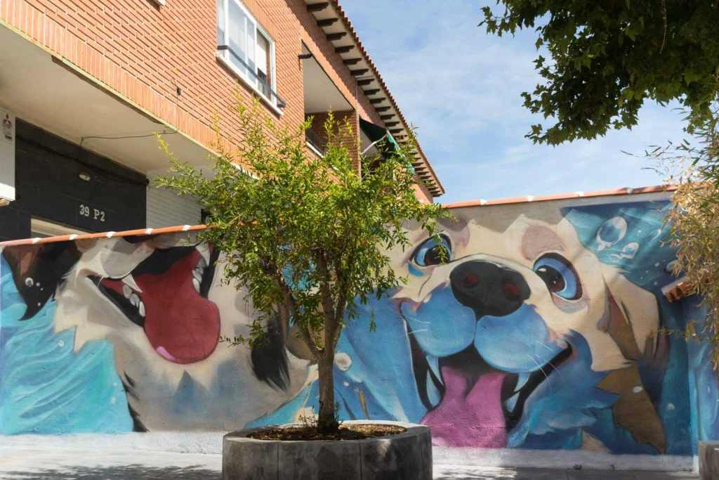 Mural con perros felices en fachada de clínica veterinaria en Toledo