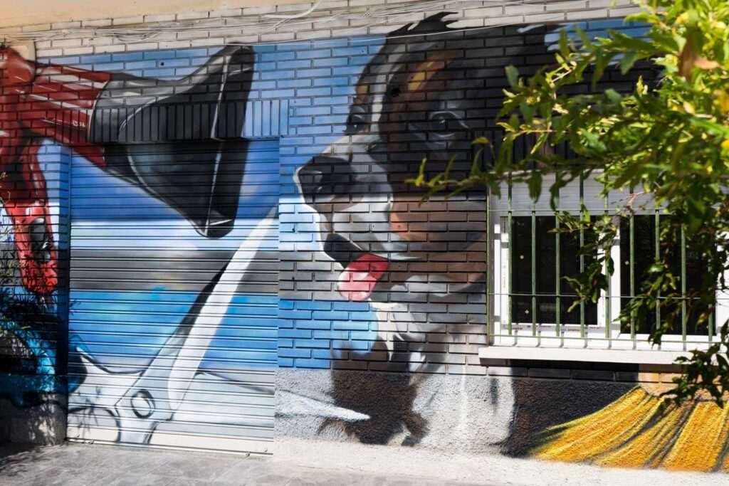 Mural con perros felices en fachada de clínica veterinaria en Toledo