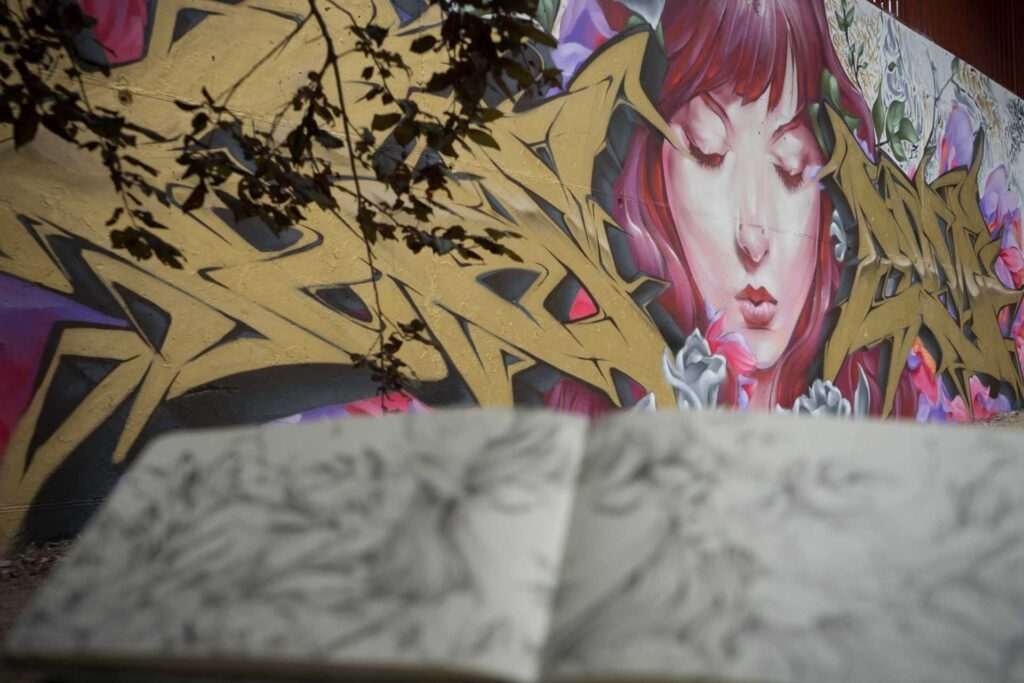 Detalle del lettering dorado del mural Angel Cry en un patio escolar