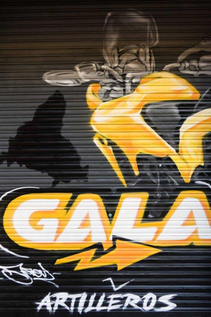 Cierre pintado de Autoescuela Gala con camión y moto en estilo urbano