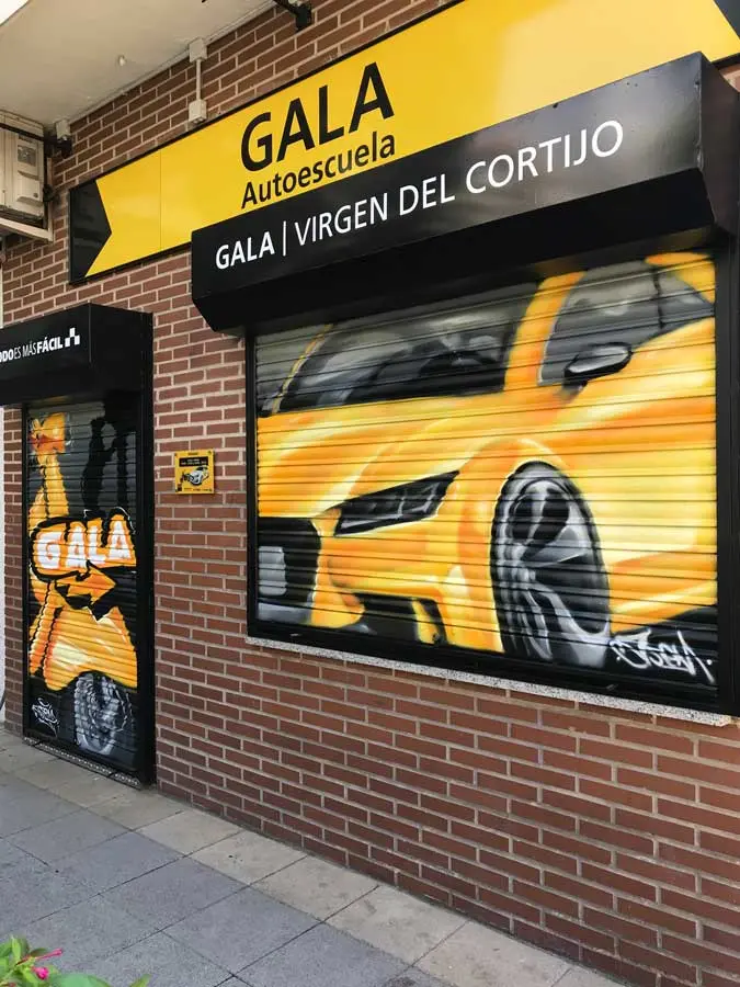 Cierres pintados con coche amarillo en Autoescuela Gala de Hortaleza (Virgen del Cortijo)