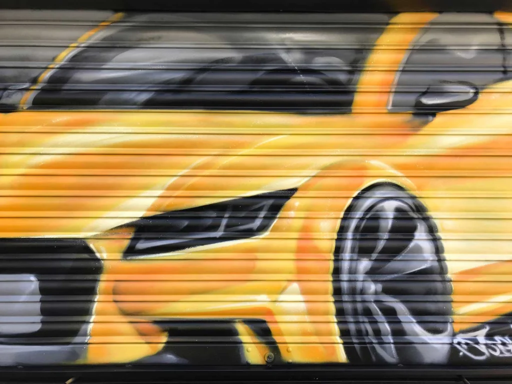 Cierres pintados con coche amarillo en Autoescuela Gala de Hortaleza (Virgen del Cortijo)