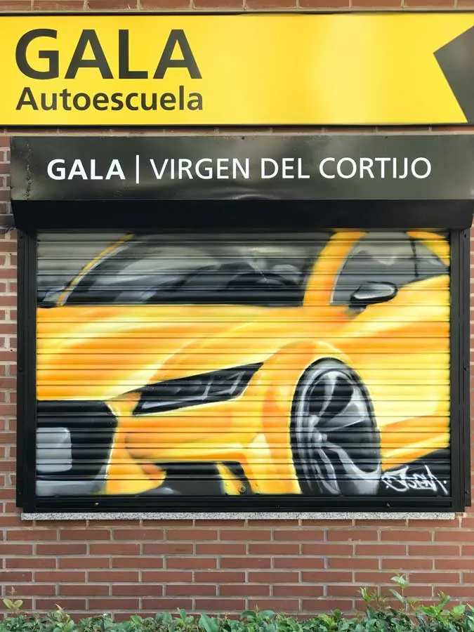 Cierres pintados con coche amarillo en Autoescuela Gala de Hortaleza (Virgen del Cortijo)