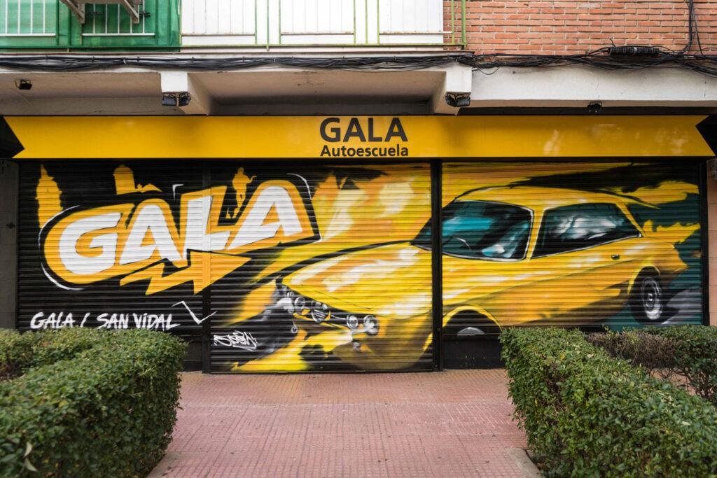 Cierre con mural de Rolls-Royce amarillo para Autoescuela Gala en estilo graffiti
