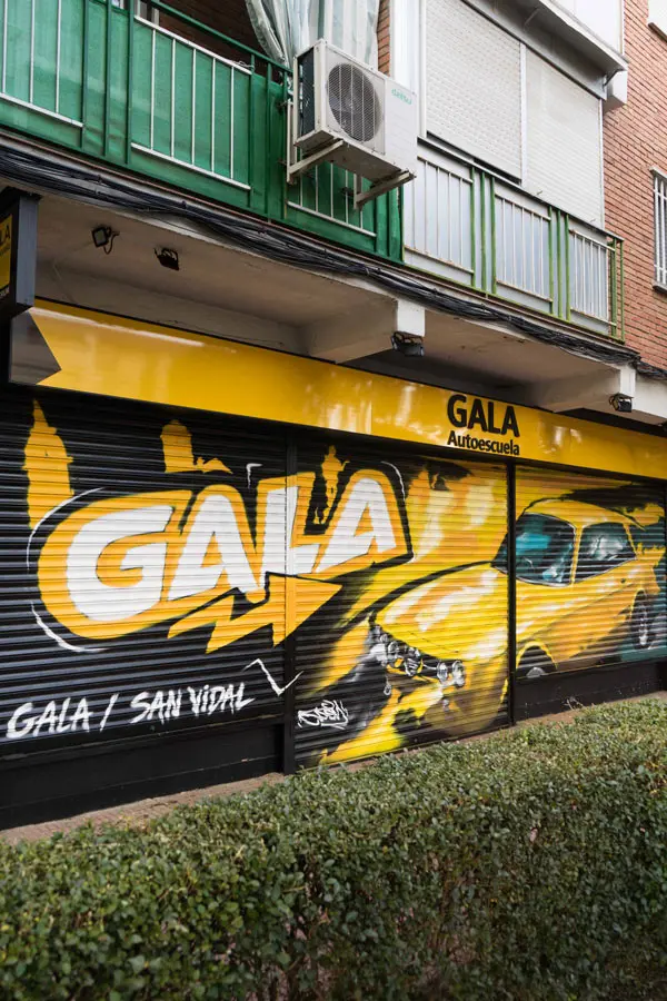 Cierre con mural de Rolls-Royce amarillo para Autoescuela Gala en estilo graffiti