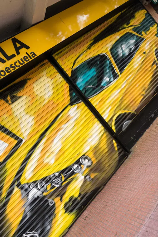 Cierre con mural de Rolls-Royce amarillo para Autoescuela Gala en estilo graffiti