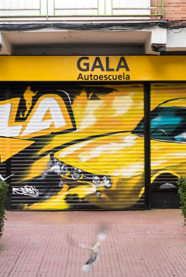 Cierre con mural de Rolls-Royce amarillo para Autoescuela Gala en estilo graffiti