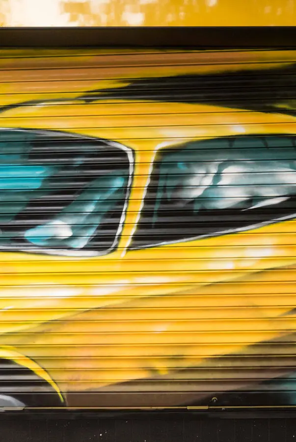 Cierre con mural de Rolls-Royce amarillo para Autoescuela Gala en estilo graffiti