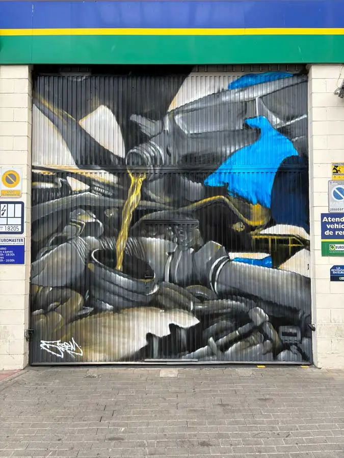Mural mecánico realista en taller Euromaster Usera con motor y ruedas