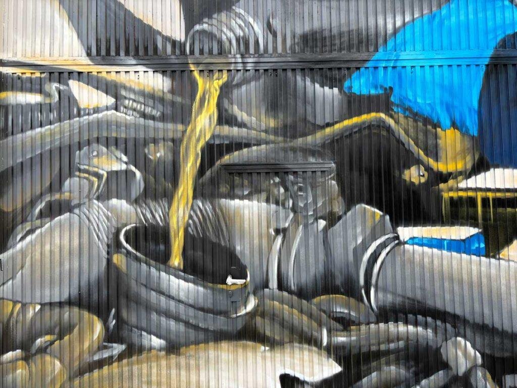 Graffiti de mecánica y engranajes en fachada de Euromaster Julián Camarillo