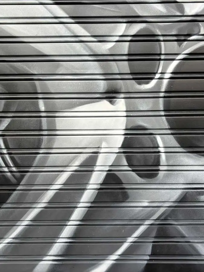 Graffiti de mecánica y engranajes en fachada de Euromaster Julián Camarillo