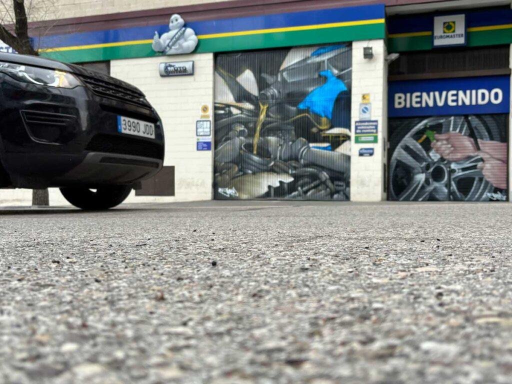 Mural mecánico realista en taller Euromaster Usera con motor y ruedas