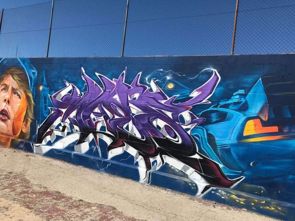 Mural graffiti de Marty McFly y el Delorean de Back to the Future con colores vivos y estilo ochentero