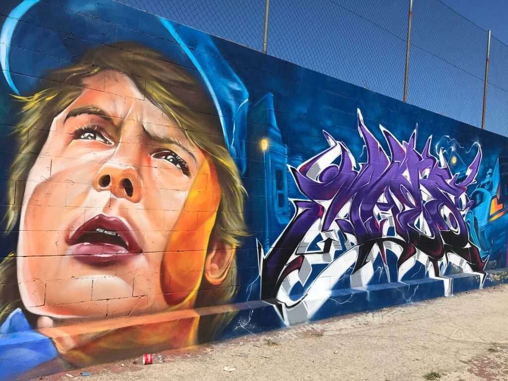 Mural graffiti de Marty McFly y el Delorean de Back to the Future con colores vivos y estilo ochentero