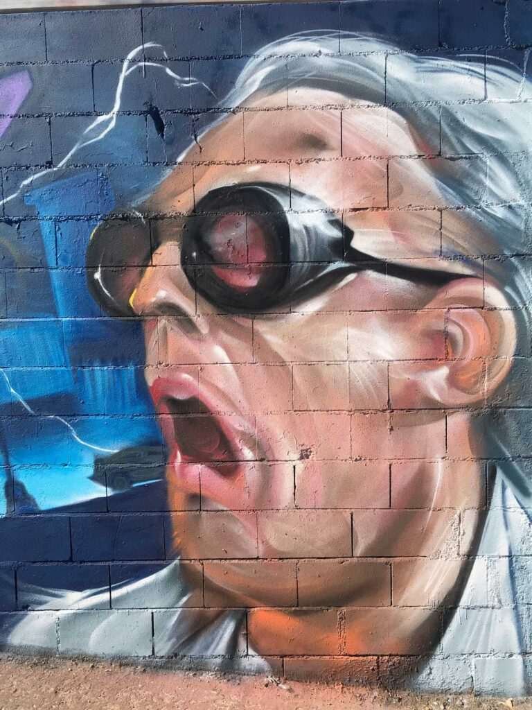 Mural graffiti de Marty McFly y el Delorean de Back to the Future con colores vivos y estilo ochentero