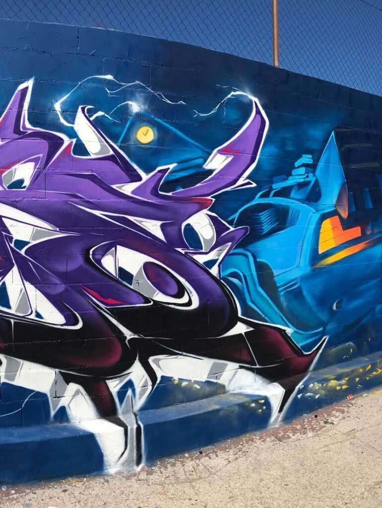 Mural graffiti de Marty McFly y el Delorean de Back to the Future con colores vivos y estilo ochentero