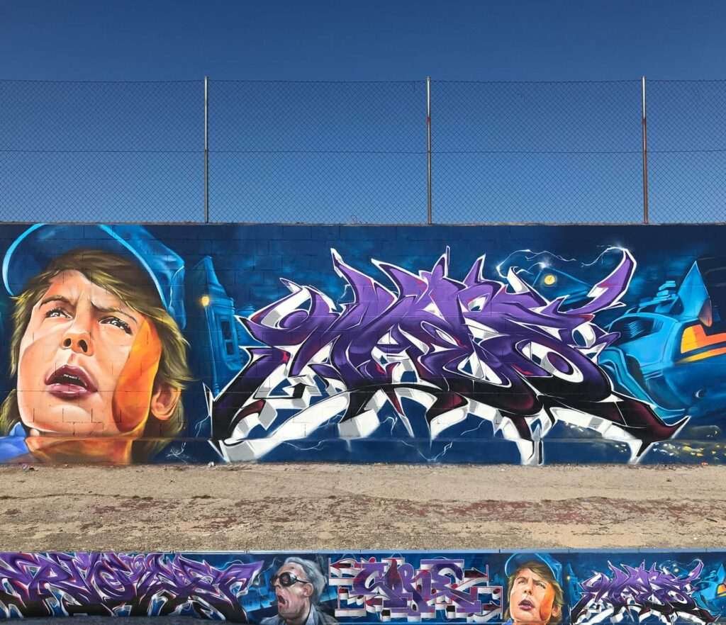 Mural graffiti de Marty McFly y el Delorean de Back to the Future con colores vivos y estilo ochentero