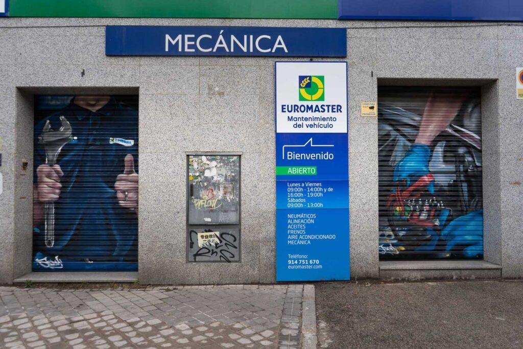 Mural mecánico realista en taller Euromaster Usera con motor y ruedas