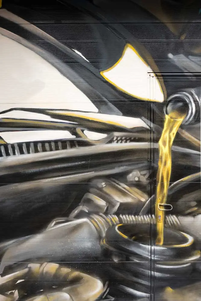 Mural mecánico realista en taller Euromaster Usera con motor y ruedas