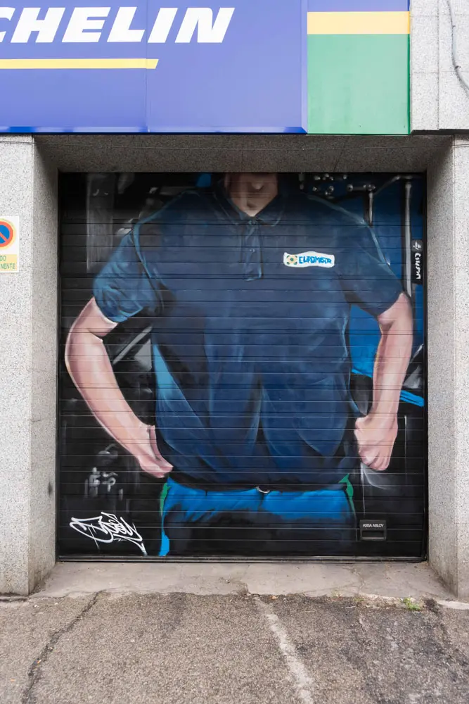 Mural mecánico realista en taller Euromaster Usera con motor y ruedas