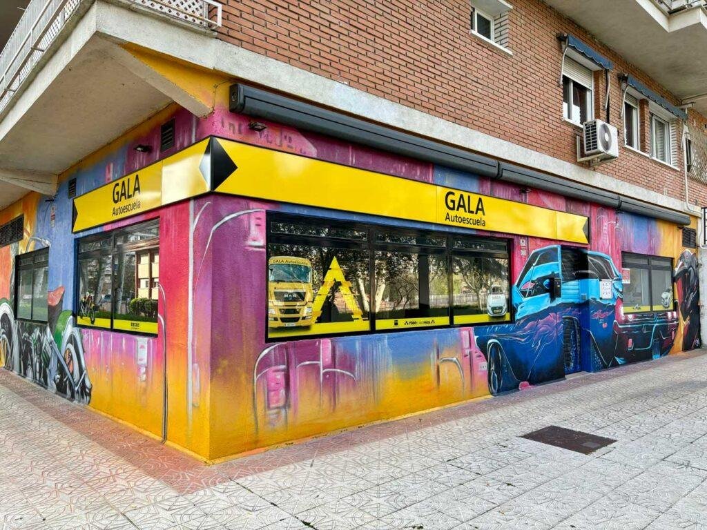 Detalle de coche deportivo pintado con graffiti en la fachada de GALA Autoescuela