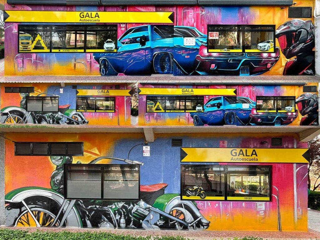 Composición del graffiti de fachada de GALA Autoescuela en Móstoles con coches, motos y estilo urbano
