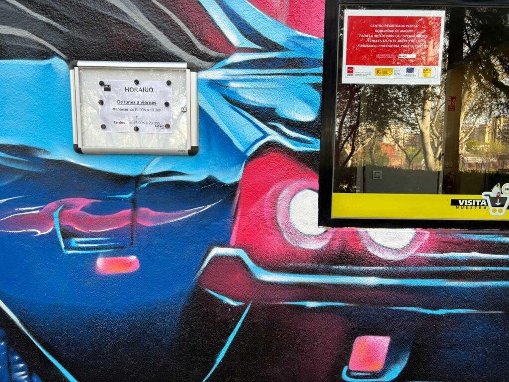 Detalle del coche deportivo azul y negro en el mural de fachada de GALA Autoescuela Móstoles
