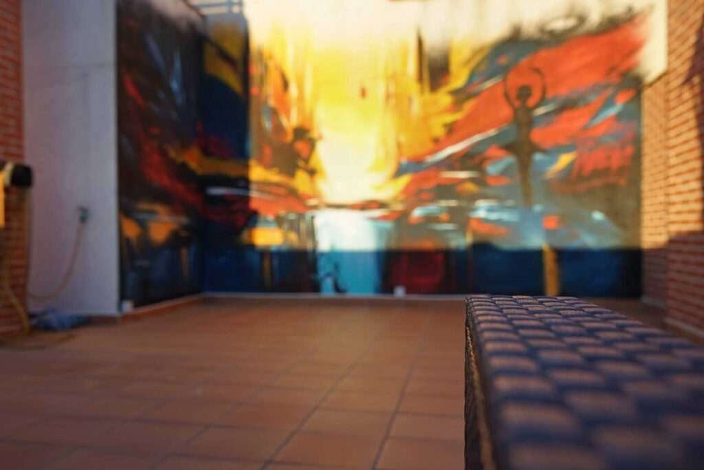 Mural artístico en terraza privada con siluetas y paisajes cálidos