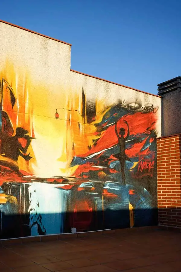 Mural artístico en terraza privada con siluetas y paisajes cálidos