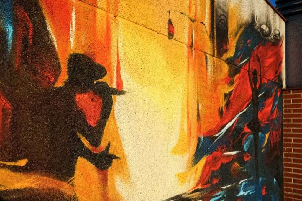 Mural artístico en terraza privada con siluetas y paisajes cálidos