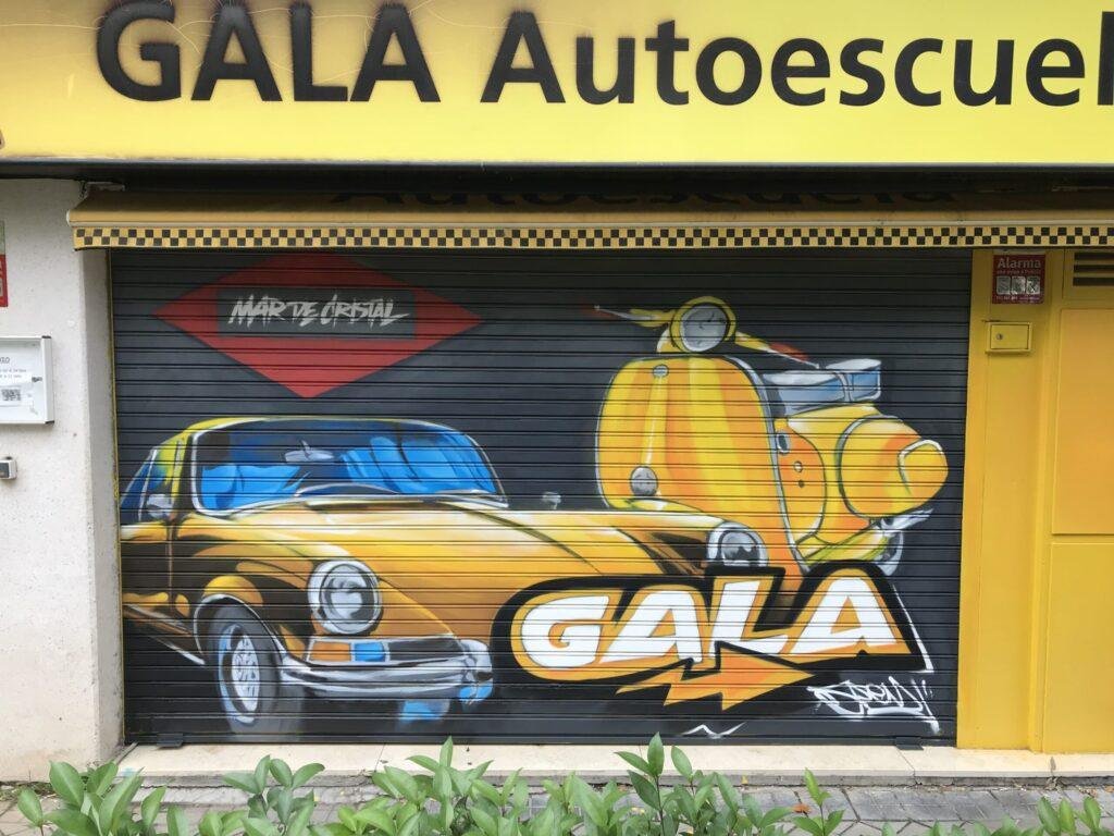 Graffiti en persiana de GALA Autoescuela Mar de Cristal con coche clásico amarillo y Vespa