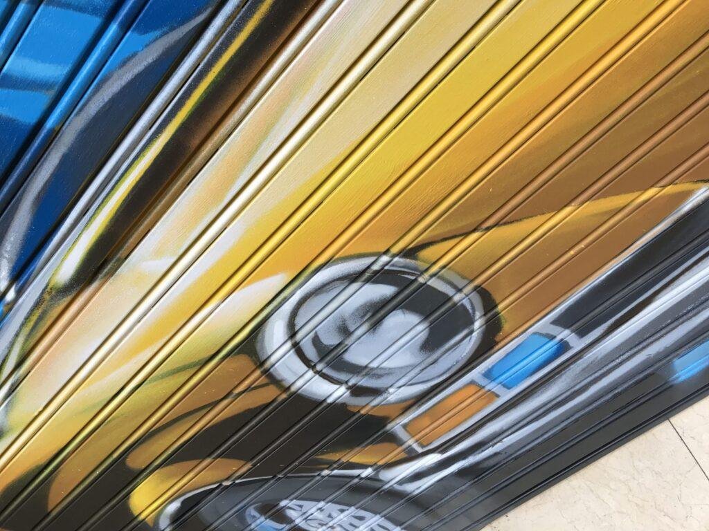 Primer plano del faro y frontal del coche clásico en el graffiti de GALA Autoescuela