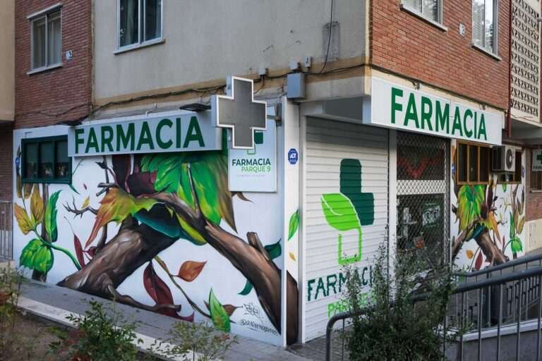 Mural con ramas y hojas en fachada de Farmacia Parque9, graffiti para imagen de salud