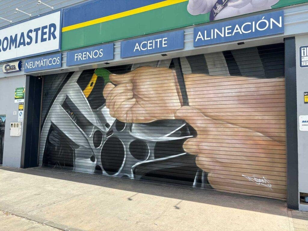 Mural de manos apretando tuerca en taller Euromaster Málaga