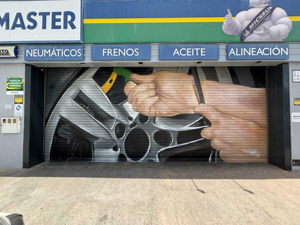 Mural de manos apretando tuerca en taller Euromaster Málaga