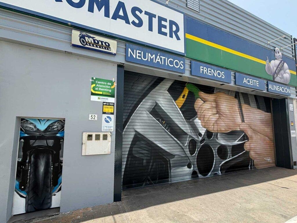 Mural de manos apretando tuerca en taller Euromaster Málaga