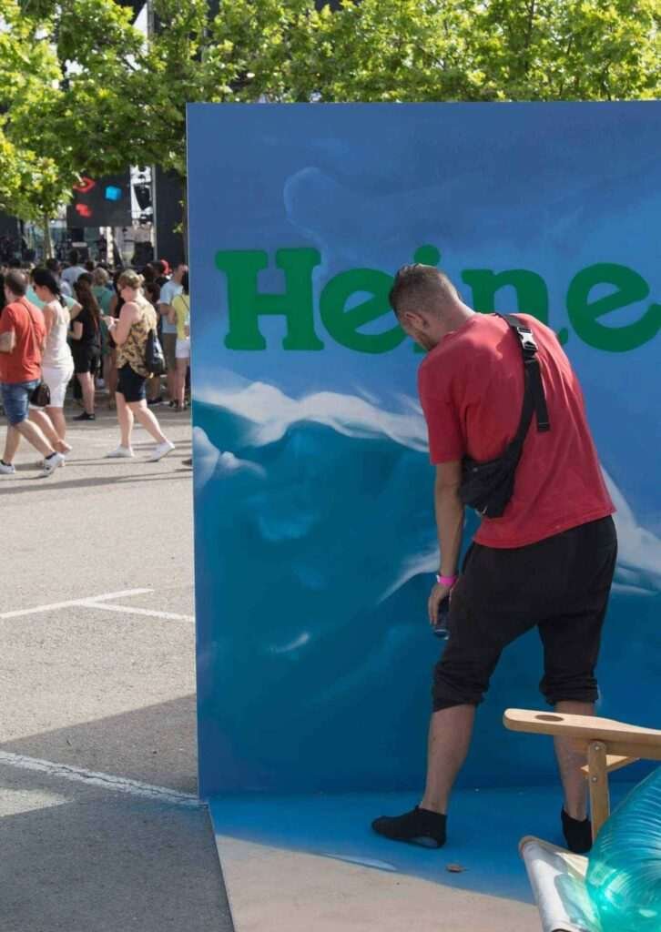 Graffiti mural para evento corporativo en Madrid para Heineken Silver con ola, palmera y zona de fotos promocional