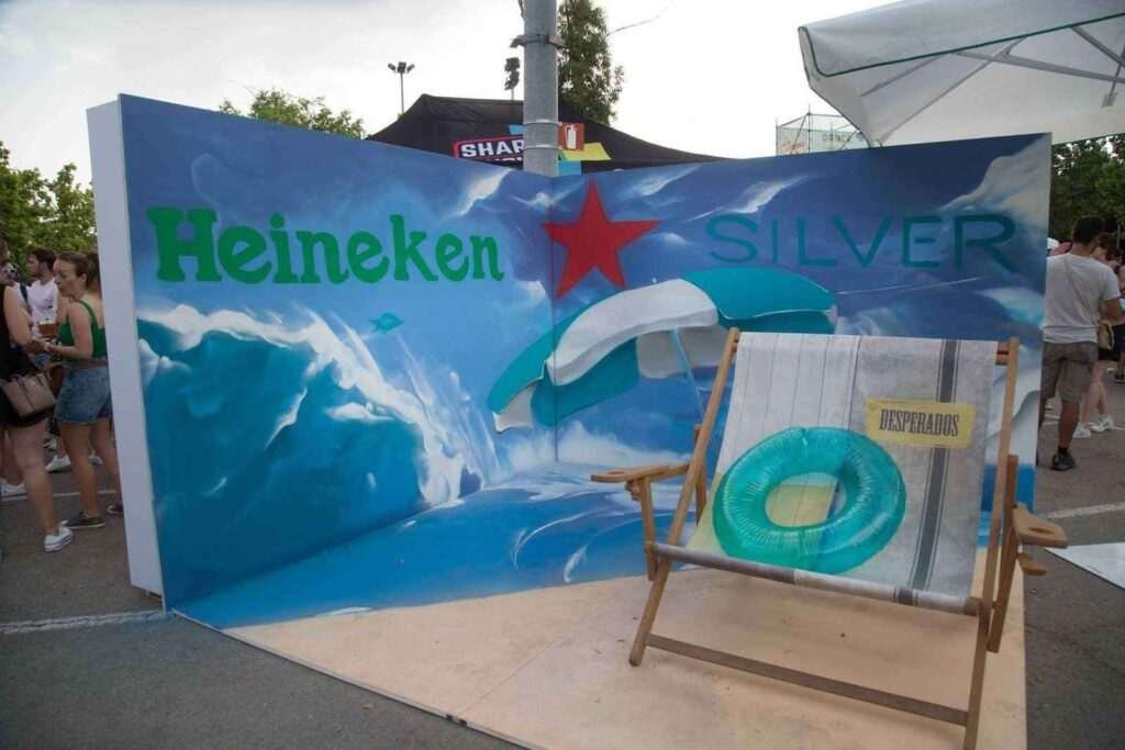 Mural para festival corporativo en Madrid para Heineken Silver con artista trabajando el paisaje marino del photocall